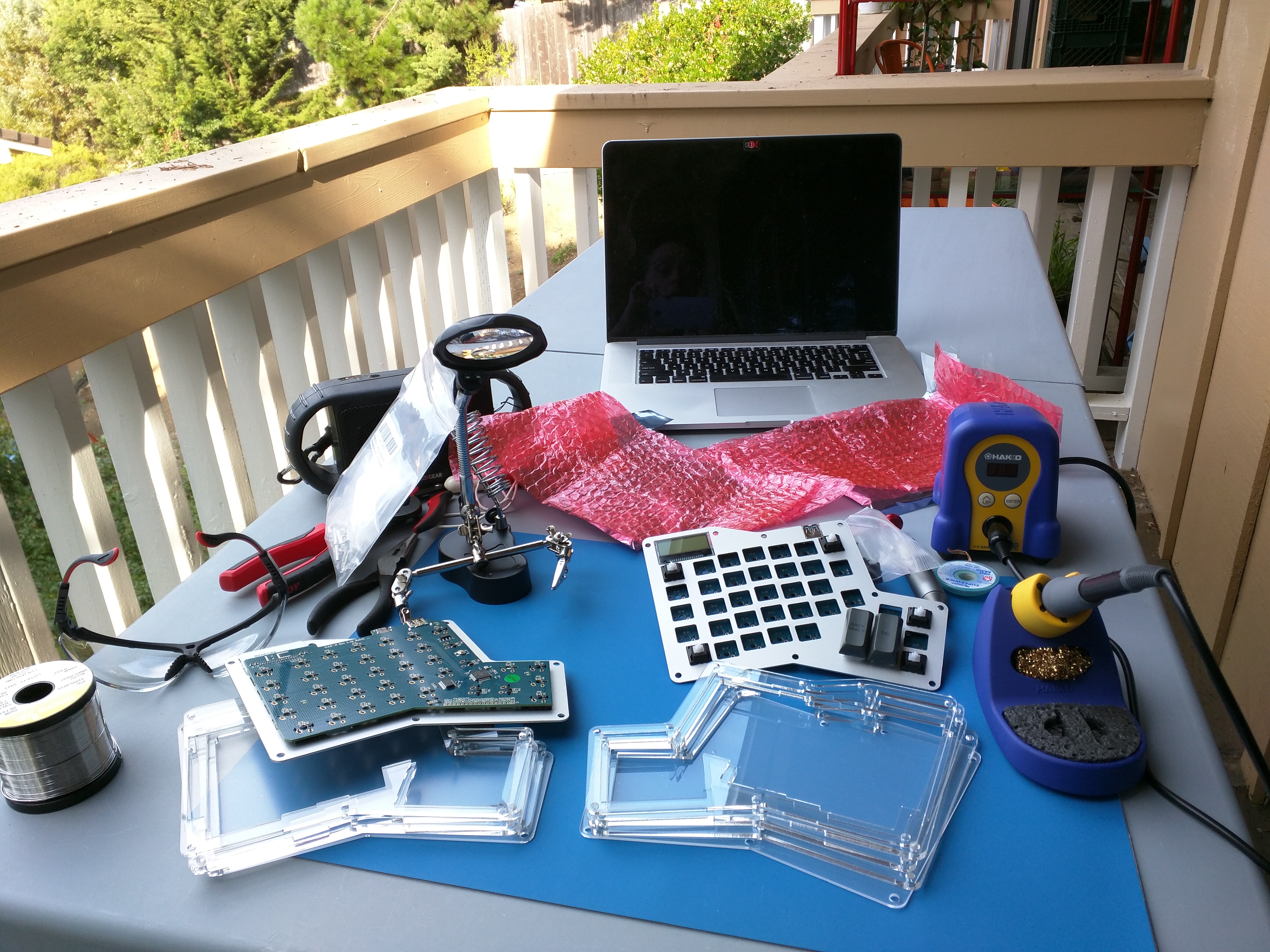 table holding the Infinity Ergodox circuit boards, a soldering station, and related equipment